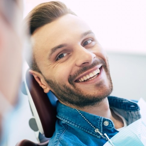 Man in dental chair smiling while visiting Louisville dental office