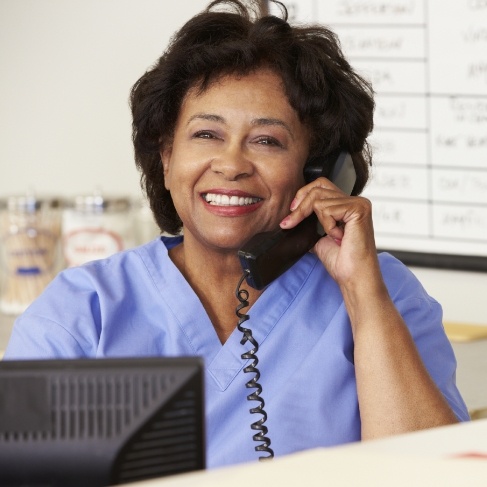 Louisville dental team member smiling while talking on phone