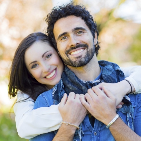 Man and woman smiling outdoors after cosmetic dentistry in Louisville