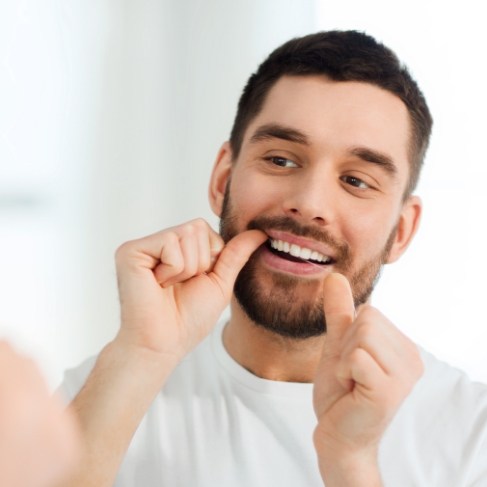 Man flossing his teeth