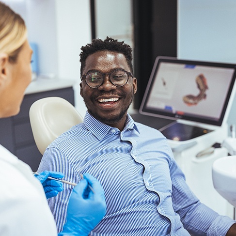 Man sitting in the dentist’s chair and smiling