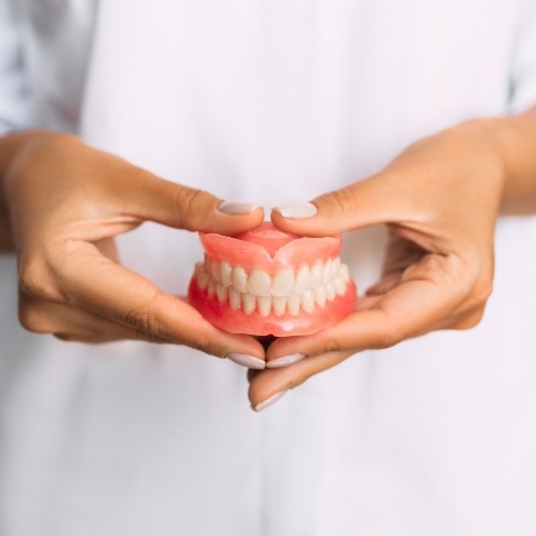 Dentist holding set of full dentures