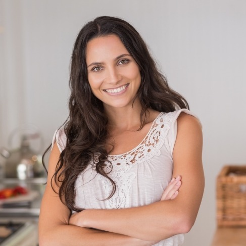 Woman in white blouse smiling after preventive dentistry in Louisville