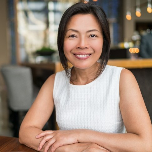 Smiling woman sitting at table in coffee shop