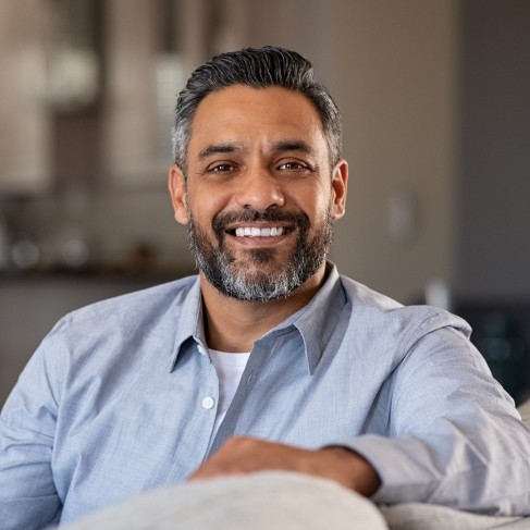 Smiling man sitting on white couch